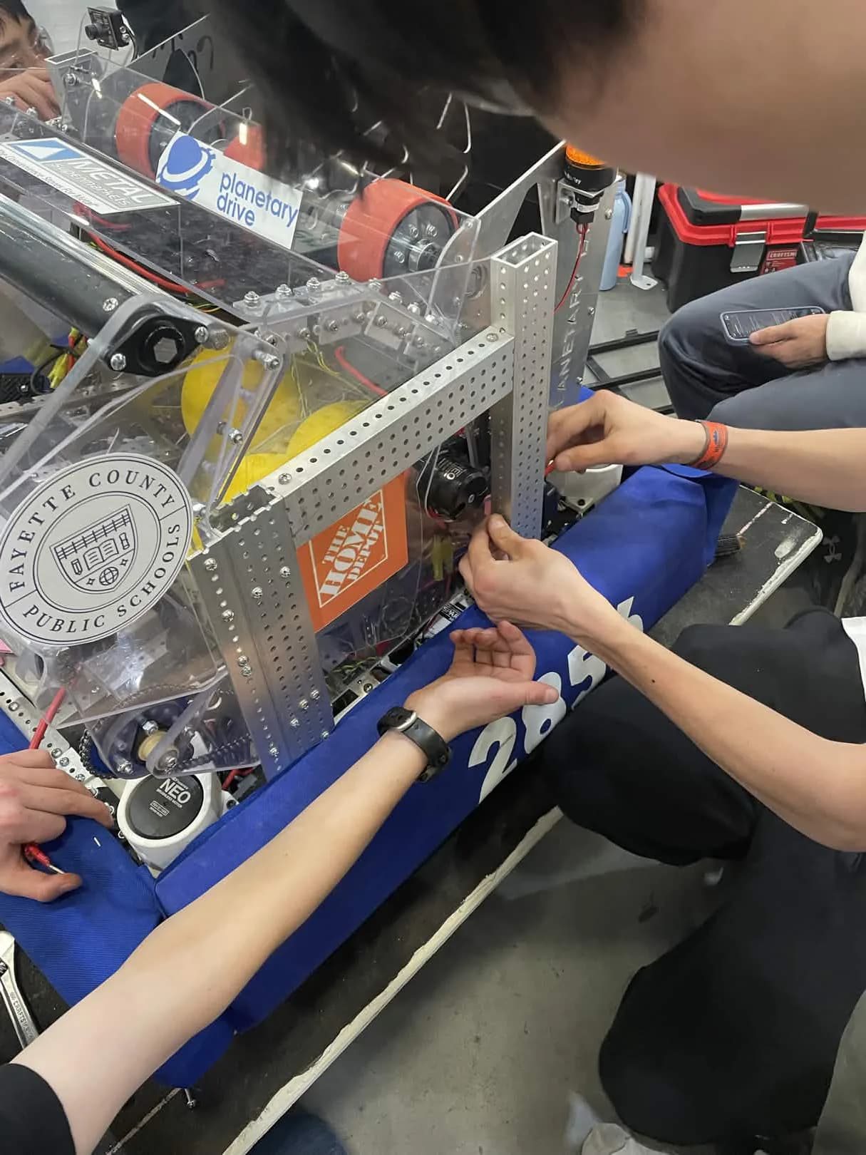 Planetary Drive students working together around their competition robot