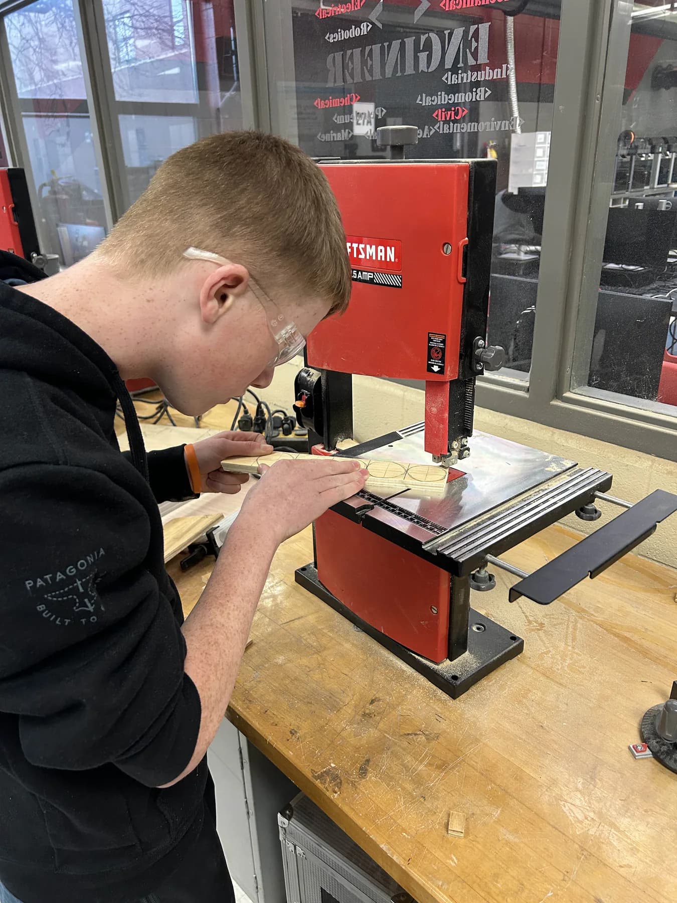 Planetary Drive student carefully using a bandsaw in the workshop
